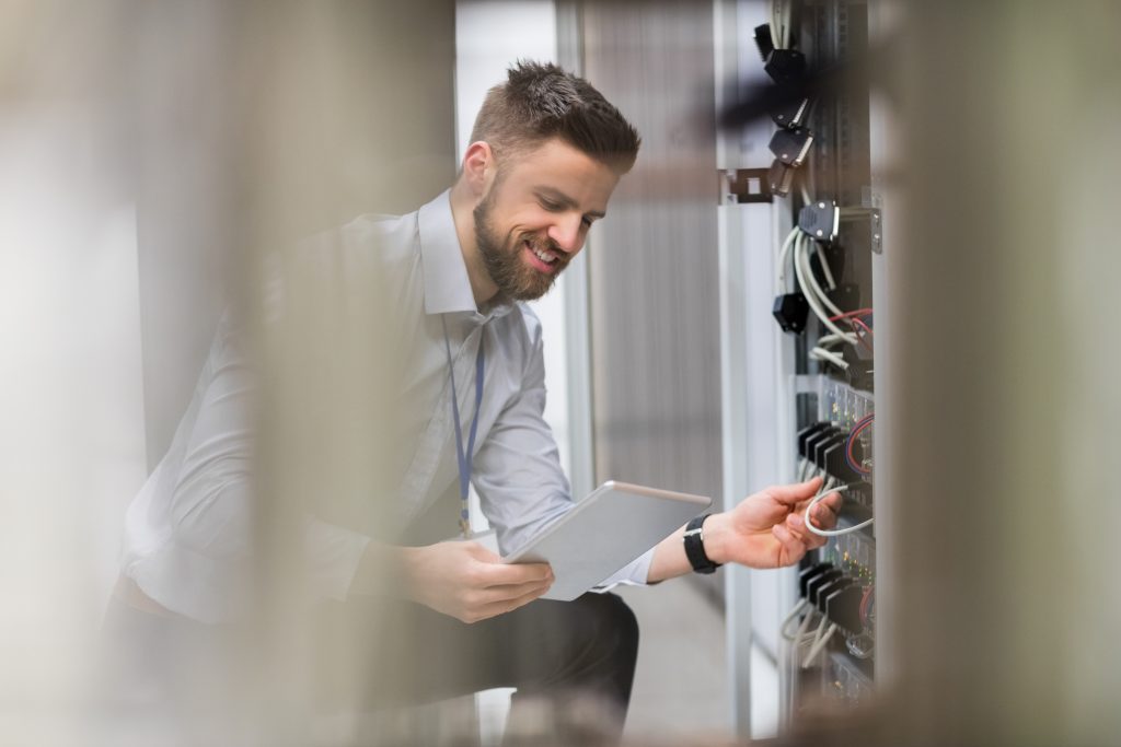 Technician Using Digital Tablet While Analyzing Server