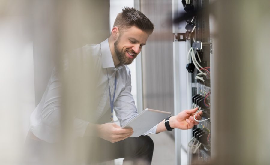 Technician Using Digital Tablet While Analyzing Server
