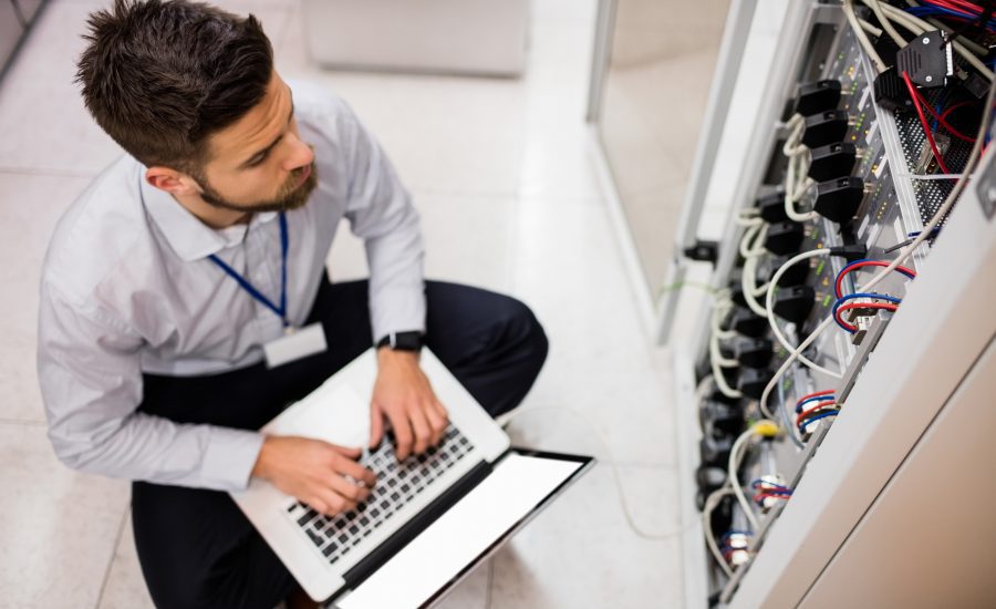 Technician Using Laptop While Analyzing Server