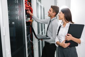 Ein Team aus jungen Geschäftsleuten, IT-Ingenieure im Netzwerk-Serverraum, die Probleme lösen sowie Hilfe und Support leisten