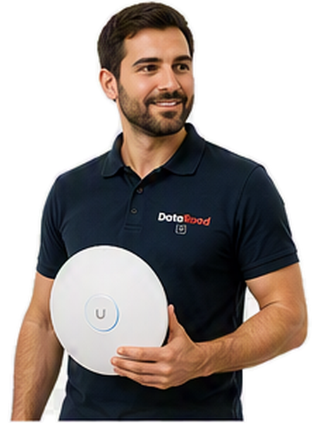 Bearded man in a navy polo shirt holding a round white wireless device with a blue ring and a 'U' button, wearing a DotaRoad logo polo.